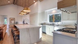 A modern kitchen with a large island, white cabinetry, and a gas stove. - Brand New Home on 2 Acres - Amazing Deck/Views - Hot Tub/BBQ/Fire Table/AC (Durango)