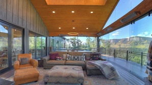 A spacious living area with a large sofa, ottoman, and armchair, a wooden ceiling, and a view of a mountainous landscape through large windows. - Brand New Home on 2 Acres - Amazing Deck/Views - Hot Tub/BBQ/Fire Table/AC (Durango)