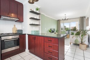 A modern kitchen with dark wooden cabinets, a Bosch oven, and a central island with a sink.
