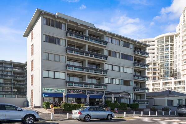 A multi-story hotel with balconies, a laundry service, a cafe, and an eatery.