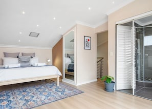 A bedroom with a bed, bedside table, and a potted plant. - The Tygervalley Escape (Cape Town)