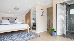 A bedroom with a bed, bedside table, and a potted plant. - The Tygervalley Escape (Cape Town)