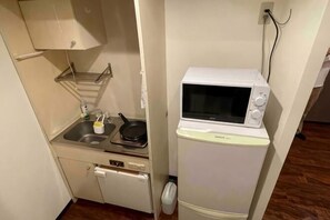 A compact kitchenette with a microwave, sink, and a small refrigerator. - Iorishimodera (Osaka)