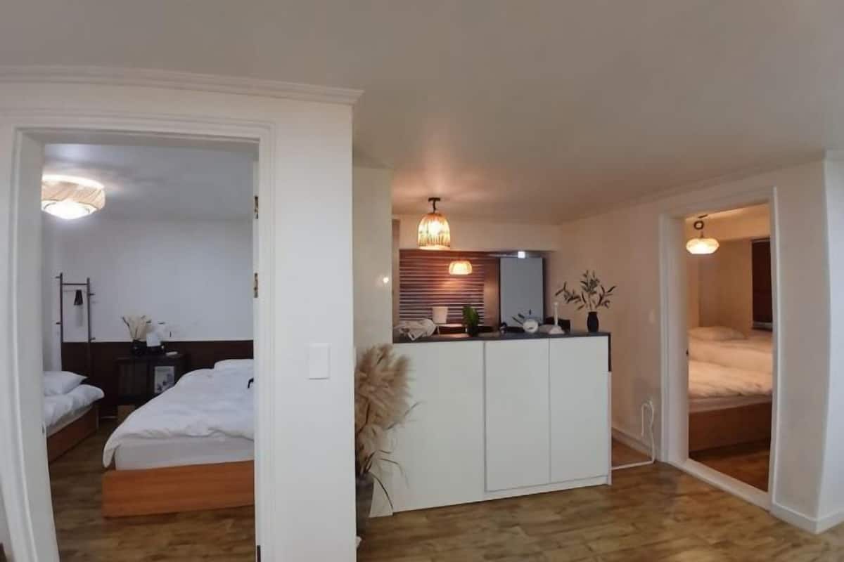 Um quarto com uma cama, mesa de cabeceira e um guarda-roupa.