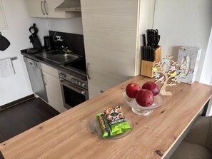 Une cuisine avec un plan de travail en bois, un évier, une cuisinière et un placard.