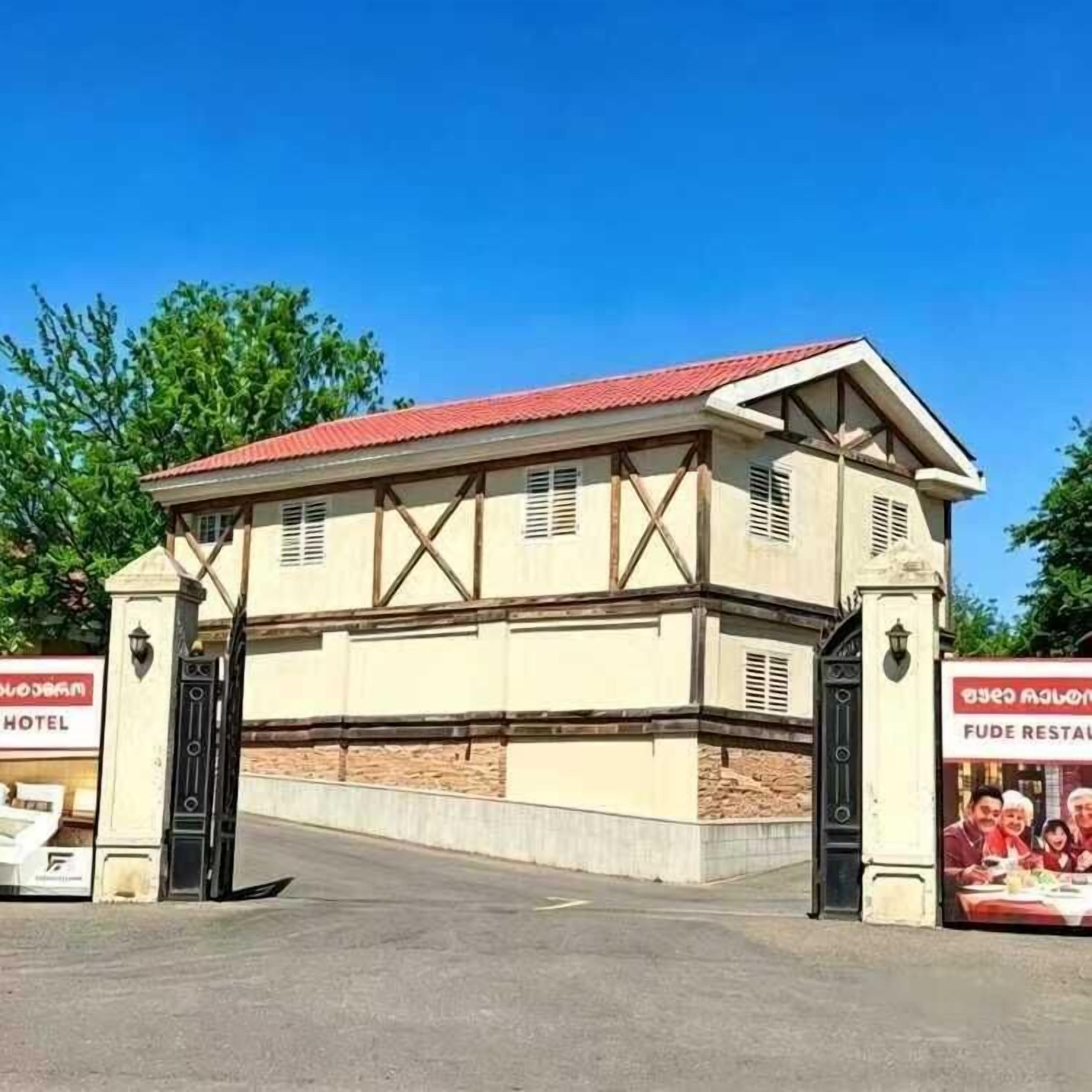 A building with a red roof and a sign for a hotel and restaurant.