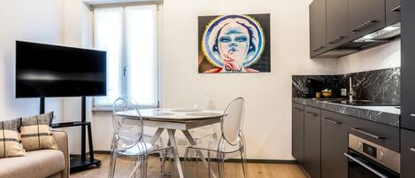 Una cocina moderna con una mesa de comedor, sillas y un televisor.