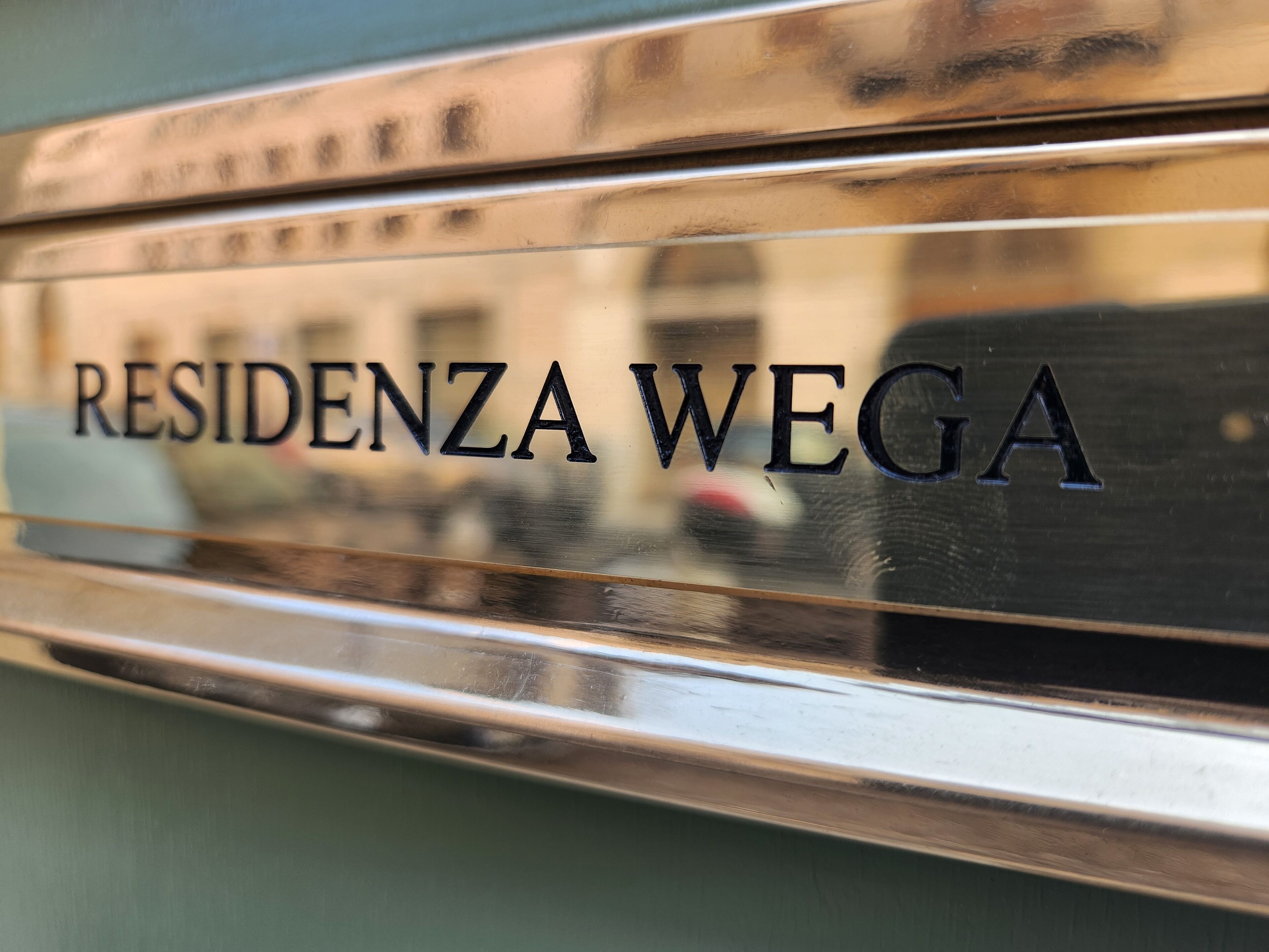 Une plaque métallique portant l’inscription « RESIDENZA WEGA ».