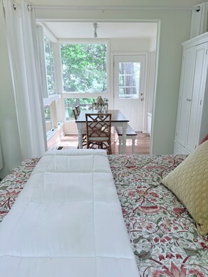 Une chambre à coucher avec un lit, une fenêtre et une vue sur l’espace repas.