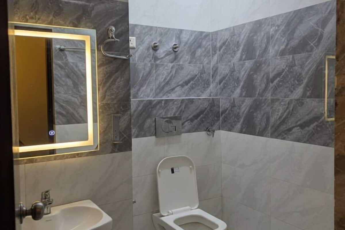 A bathroom with a toilet, sink, and mirror.