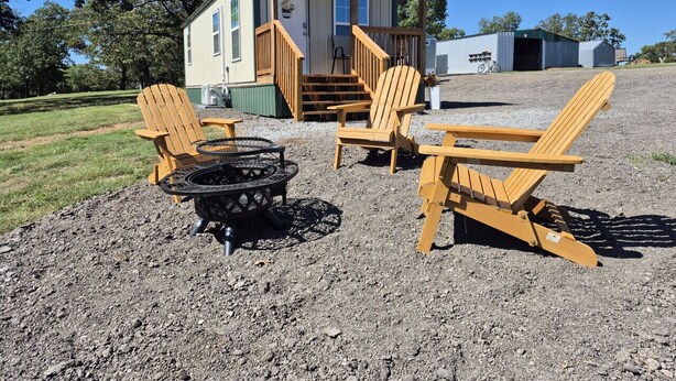 A cabin with a porch, outdoor seating, and a fire pit. - Little Barnstead Tiny Home (Big Cabin)