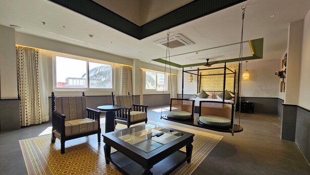 A spacious hotel lobby with a large seating area, a glass coffee table, and a four-poster bed in the background. - Azydo, Art House, Grand Road, Near Jagannath Mandir (Puri)