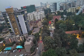 Une vue urbaine avec de hauts immeubles, un parking et une piscine.