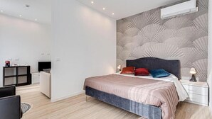 Una camera da letto moderna con un letto, comodini e una parete decorata.