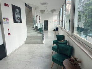 A modern interior with a staircase, green chairs, and a large window. - Anversa (Rimini)