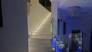 Una moderna scala con ringhiere in vetro e illuminazione d'atmosfera.