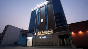 Ein Hotel namens "Hotel Buddha Pride" mit einem Schild, das Zimmer, ein Restaurant und eine Bankettmöglichkeit anbietet.