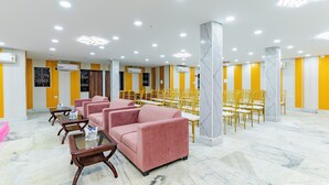 Eine Hotelhalle mit Sitzbereichen, Klimaanlagen und einem Marmorboden.