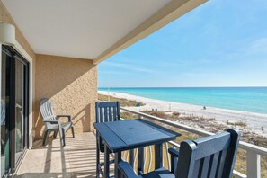 A balcony with a table and chairs overlooking a beach. - Crystal Villas B9 New Listing Specials! Gulf Front, Pool, Free Beach Service (Destin)