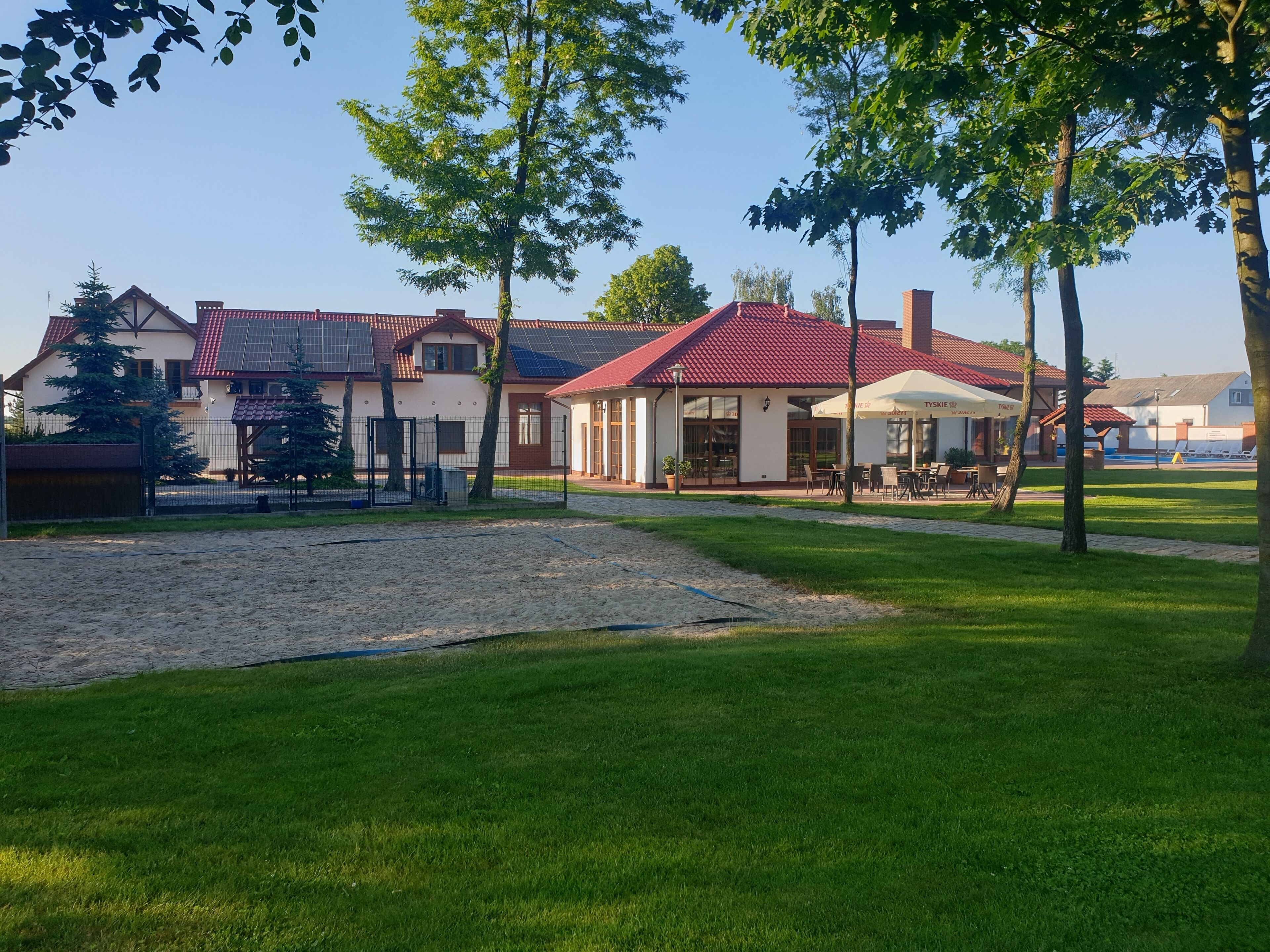 A residential area with houses, a swimming pool, and outdoor seating areas.