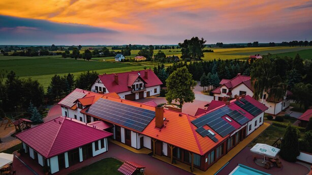 A residential area with multiple houses, a swimming pool, and solar panels on the roofs. - Azretreat (gmina Ostrowite)