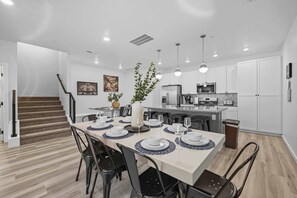 A modern kitchen with white cabinets, a built-in oven, and a stainless steel refrigerator.