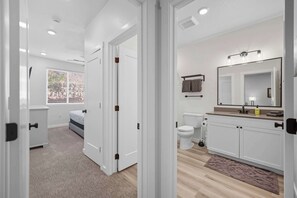 A modern bathroom with a toilet, sink, and mirror.