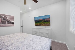 A bedroom with a bed, a dresser, a painting of a barn, and a landscape painting. - The Grand Retreat - Brand New! (Hurricane)