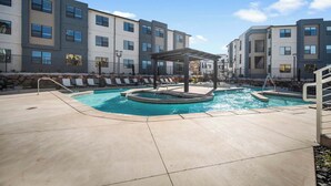 A modern apartment building with a swimming pool and outdoor seating area. - The Grand Retreat - Brand New! (Hurricane)