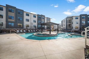 A modern apartment building with a swimming pool and outdoor seating area. - The Grand Retreat - Brand New! (Hurricane)