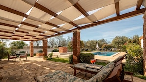 An outdoor patio with stone flooring, a pool, and a covered seating area with a table and chairs. - Villa Zdravko Zadarvillas (Škabrnja)