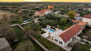 A residential area with houses, a swimming pool, and a clear view of the sunset. - Villa Zdravko Zadarvillas (Škabrnja)