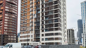 Un edificio de varios pisos con un diseño arquitectónico moderno, que combina fachadas de vidrio y concreto.