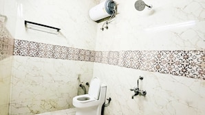 A bathroom with a toilet, a shower, and a towel rack. - Roomshala Hotel Tom & Jerry (New Delhi)
