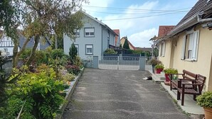 A residential street with houses, a gravel path, and potted plants. - T2 apartment 44 m2, self-contained. (Kesseldorf)