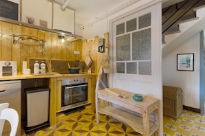 A kitchen with wooden cabinets, a built-in oven, and a window with textured glass.