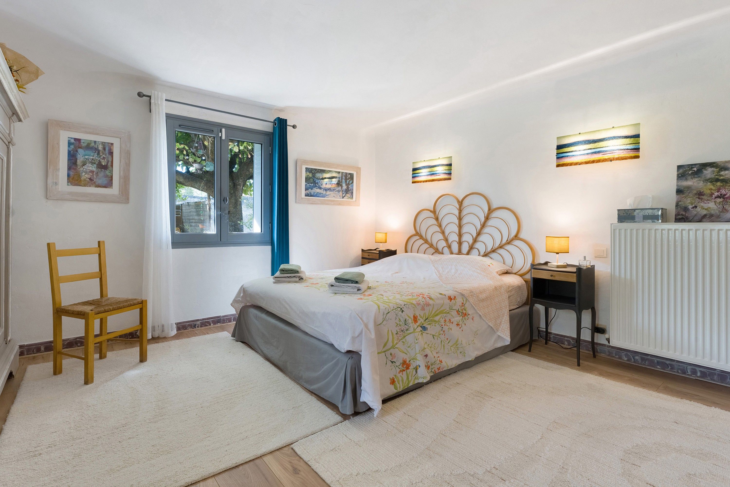 Une chambre à coucher avec un lit, une chaise, un bureau et un radiateur.