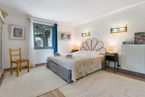 A bedroom with a bed, a chair, a desk, and a radiator. - Charming Apartment - Under the Linden Tree (Valréas)
