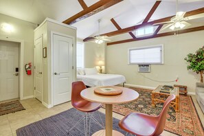 A compact room with a bed, two chairs, a small table, a ceiling fan, and a window. - Walkable Studio 1 Mi to Riverwalk & Dtwn Bradenton (Bradenton)