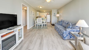 A living room with a TV, sofa, and a ceiling fan. - Steps to Sand + Pool! 3rd-floor Myrtle Beach Condo (Myrtle Beach)