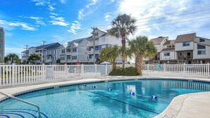 A swimming pool with a white fence, a lifeguard sign, and a palm tree. - Steps to Sand + Pool! 3rd-floor Myrtle Beach Condo (Myrtle Beach)