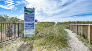A beach path with a wooden fence and informational signs. - Steps to Sand + Pool! 3rd-floor Myrtle Beach Condo (Myrtle Beach)