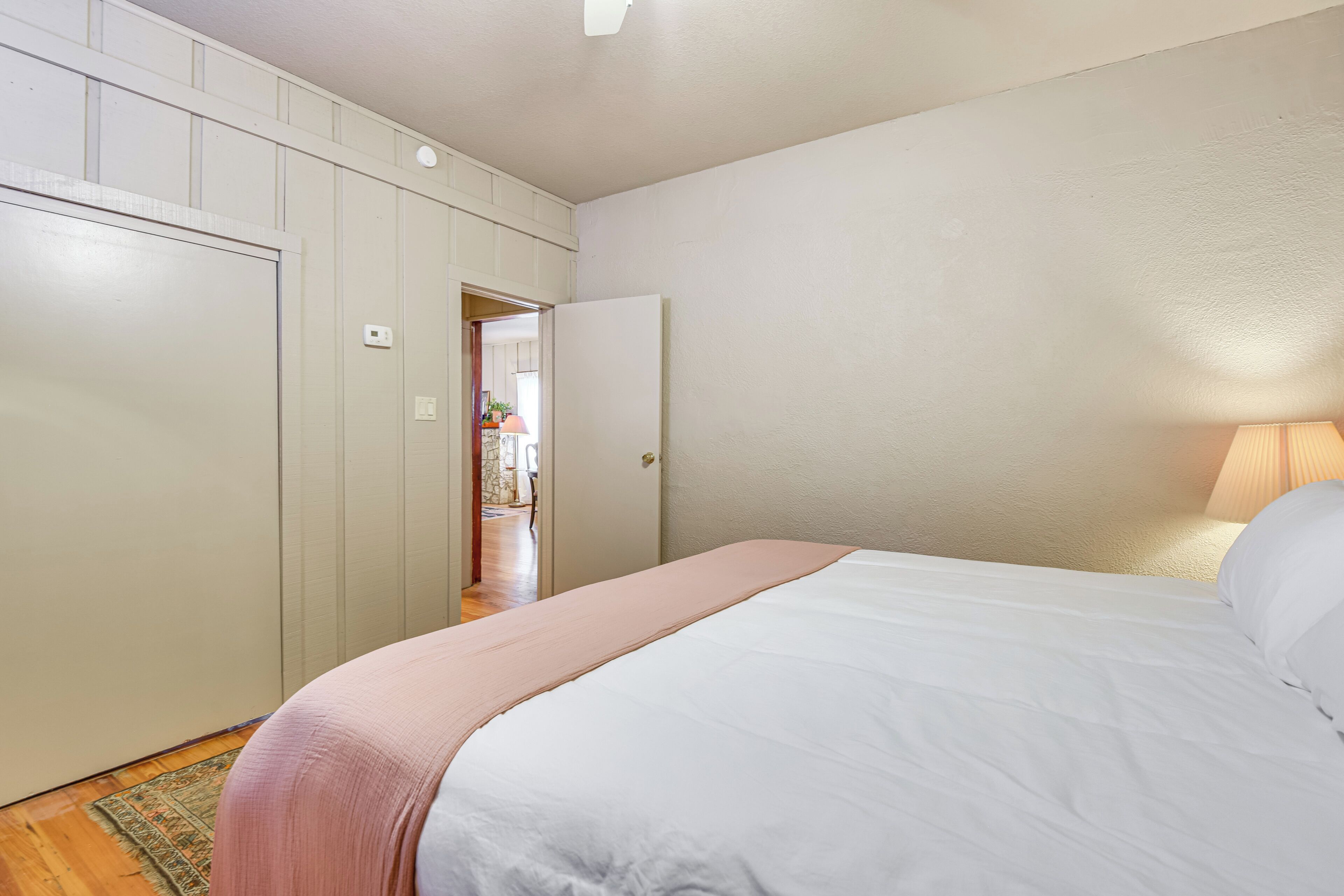 A bedroom with a bed, a wardrobe, and a door leading to another room.