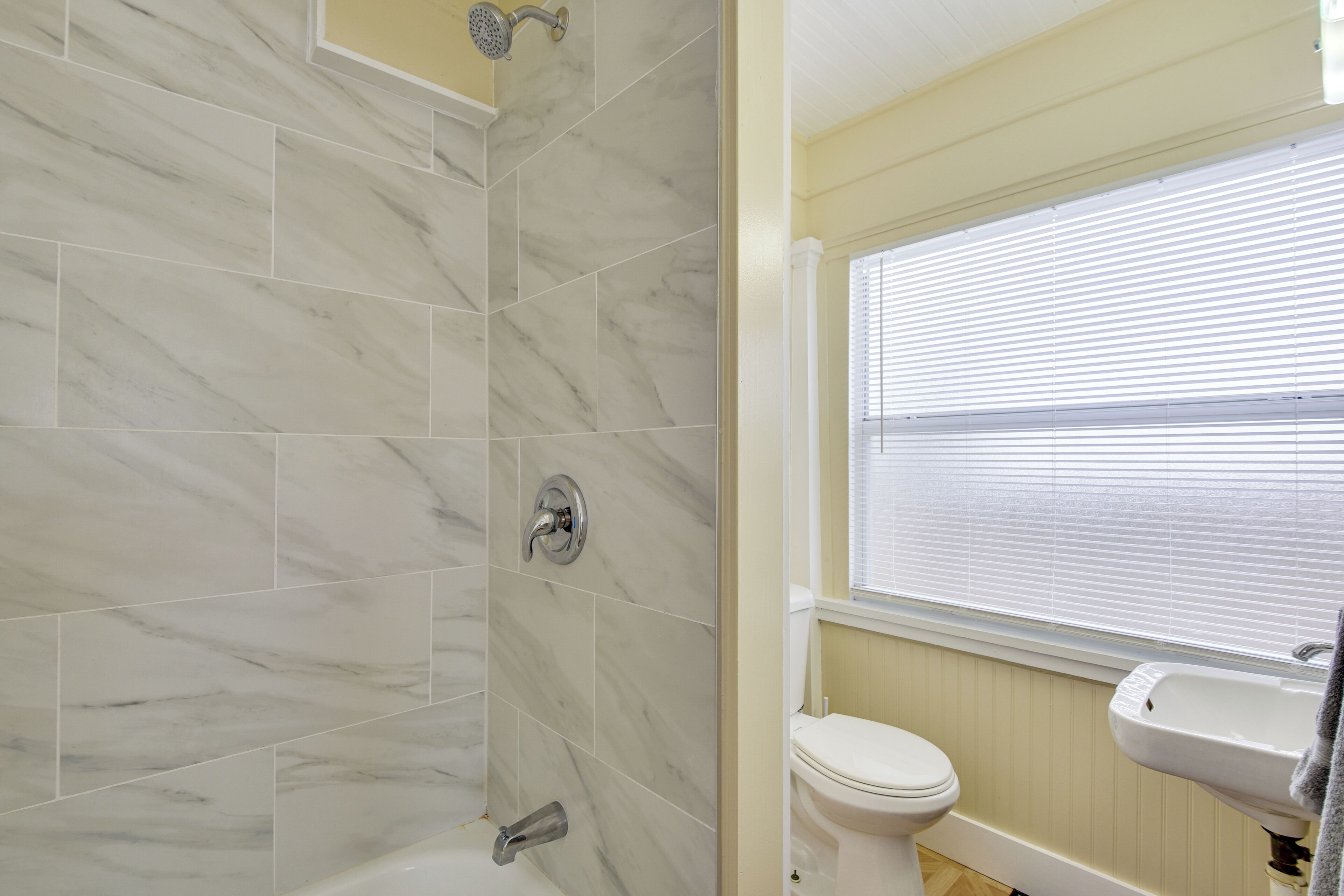 A bathroom with a shower, toilet, and sink.