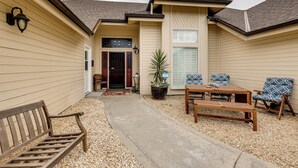 A covered patio with a concrete path, a wooden bench, a table, and two patterned chairs. - Golf, Hike, Explore: Apt 9 Mi to Dtwn Fresno! (Fresno)