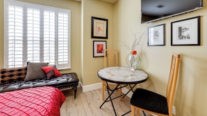 A room with a bed, a sofa, a dining table, and a TV mounted on the wall. - Golf, Hike, Explore: Apt 9 Mi to Dtwn Fresno! (Fresno)