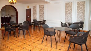 A dining area with a checkered floor, black chairs, and tables. - Whispering Palms Gardens (Nairobi)
