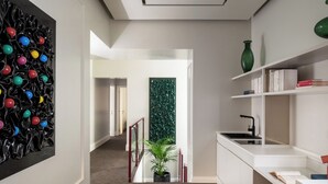 A modern kitchen with white cabinetry, a black faucet, and a green vase on the shelf. - Golden House Vatican - Regolo (Rome)