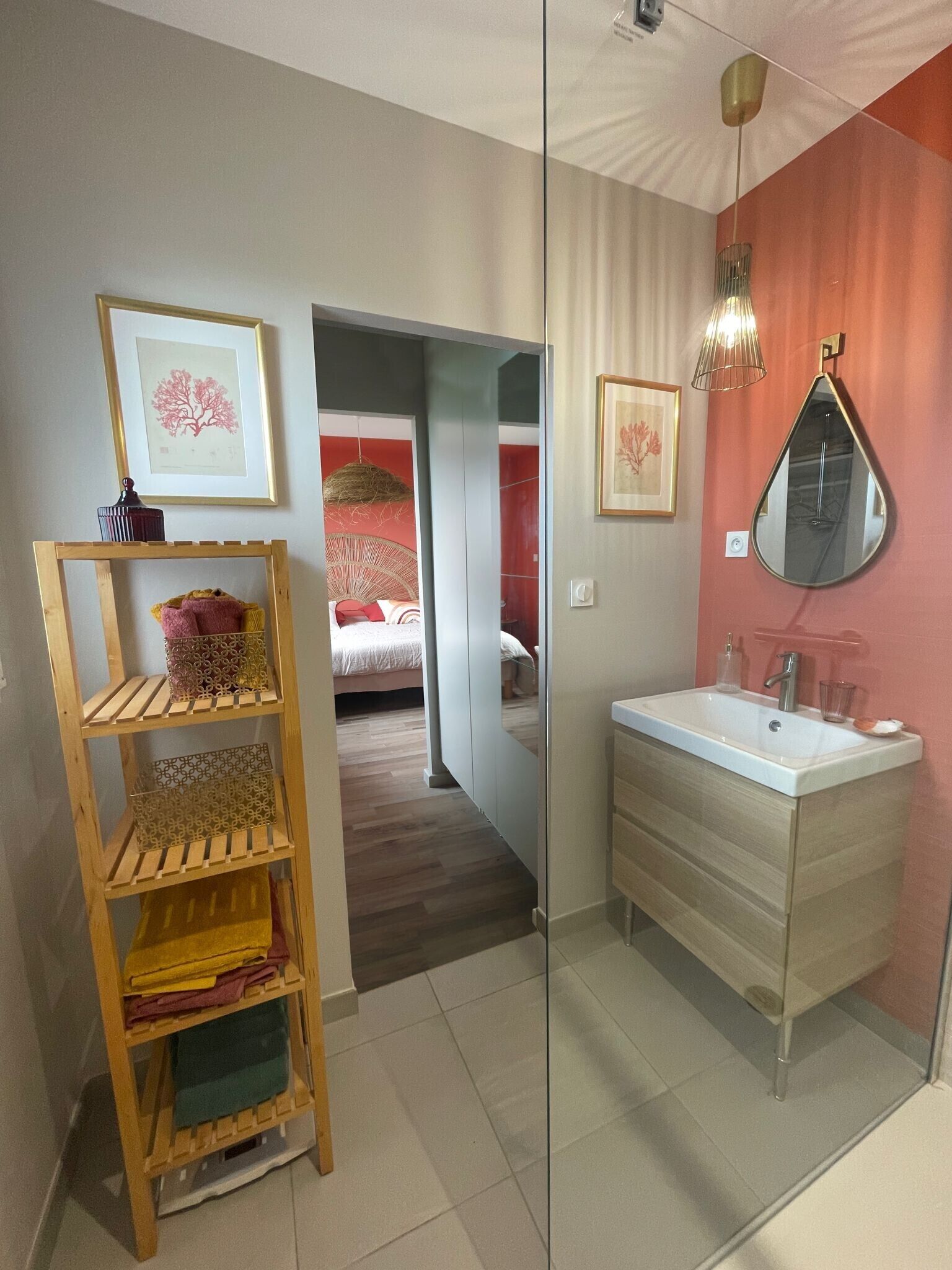 A bathroom with a sink, mirror, and a wooden shelf with towels.