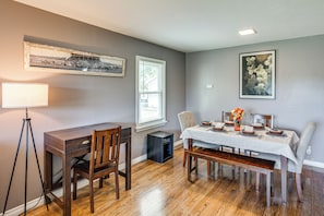 A dining area with a wooden table set for four, a bench, and a tripod lamp. - Fishing & Skiing Base! Residential Bozeman Escape (Bozeman)